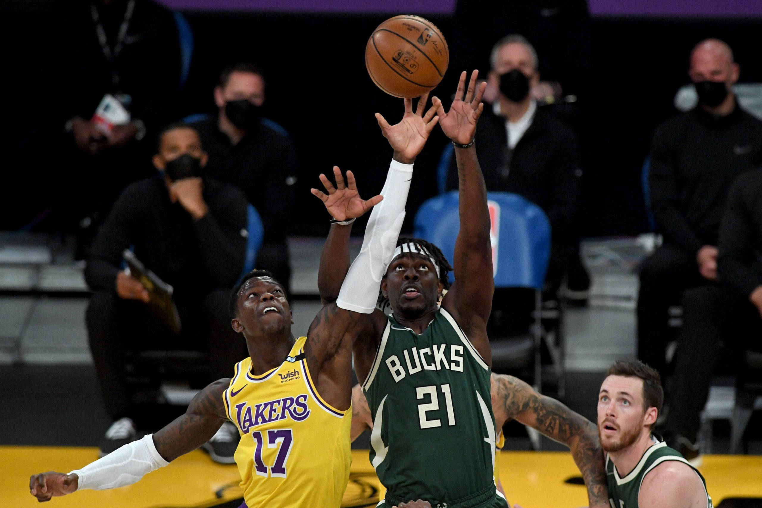 Jrue Holiday 桌布 壁紙 — 兩名籃球運動員在觀眾注視下激烈跳起爭搶籃板球。