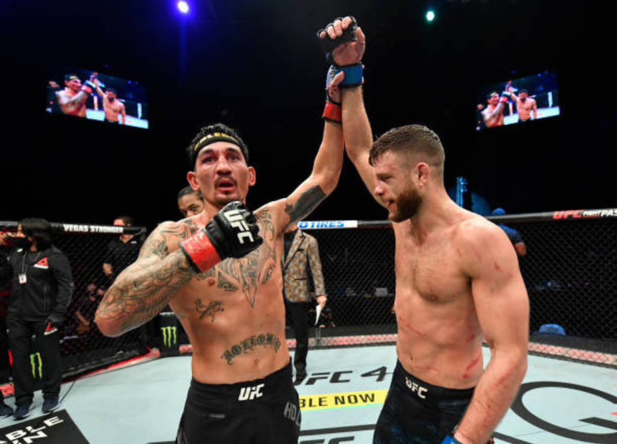 Victory 桌布 壁紙 — 兩名紋身MMA拳手在燈光明亮的八角籠中慶祝勝利，背景有粉絲和螢幕。