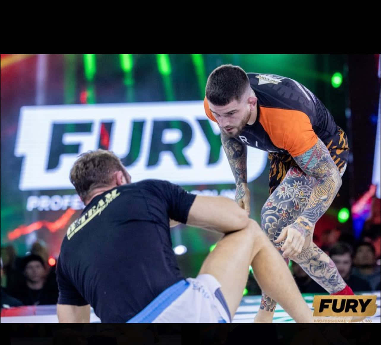 MMA 桌布 壁紙 — 兩名紋身摔角手在霓虹燈下光線明亮的職業摔角擂台上激烈纏鬥。