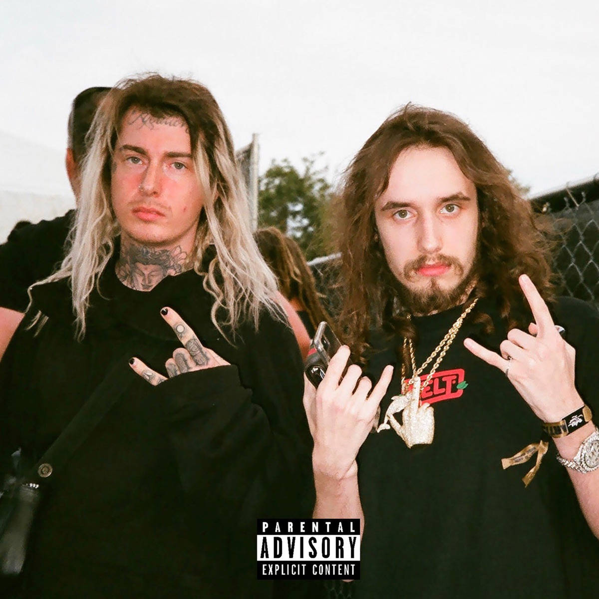 Ghostemane 桌布 壁紙 — 兩名紋身長髮男子在戶外音樂會上挑釁地擺姿勢，可見家長指引貼紙。