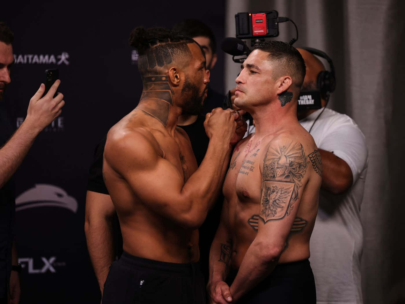 MMA 桌布 壁紙 — 兩名紋身鬥士在明亮燈光下於賽前對峙，氣氛緊張。