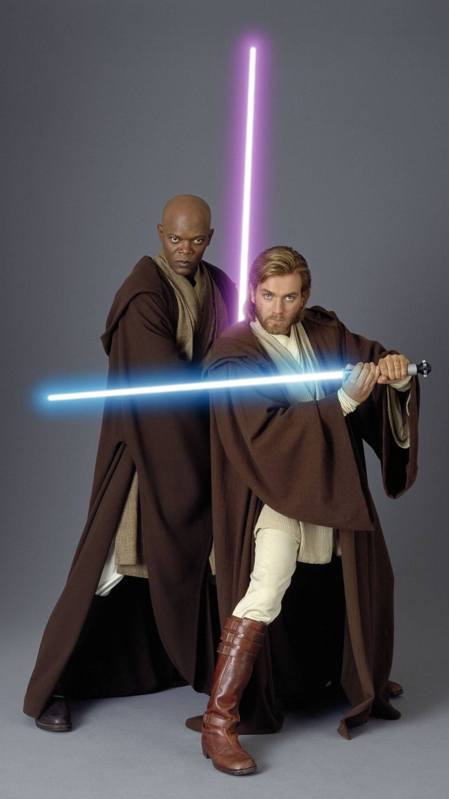 Lightsaber 桌布 壁紙 — 兩名絕地武士在純灰色工作室背景前，手持發光的藍色和紫色光劍，蓄勢待發。