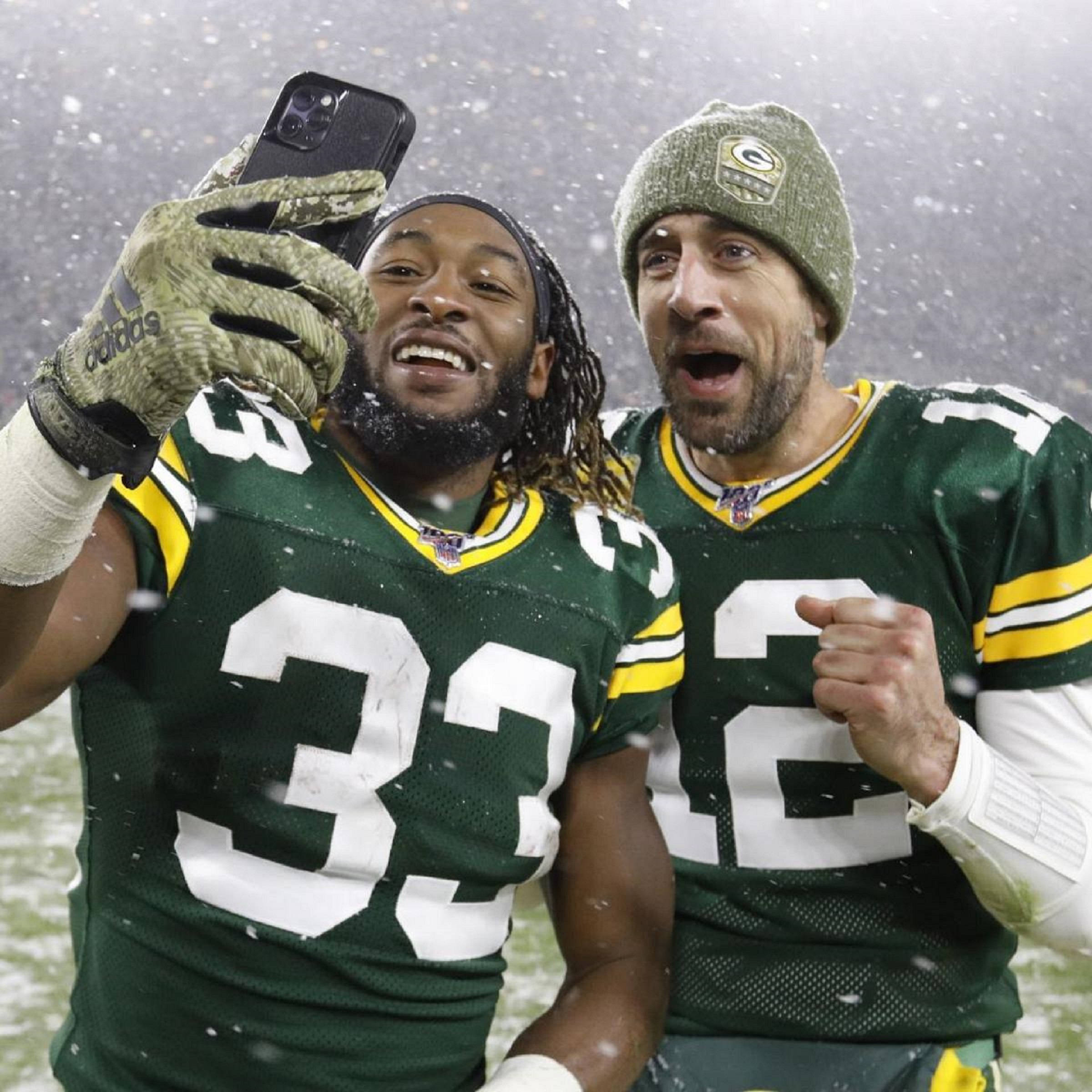 Aaron Rodgers 桌布 壁紙 — 兩名綠灣包裝工美式足球員在雪中慶祝，同時在球場上自拍。
