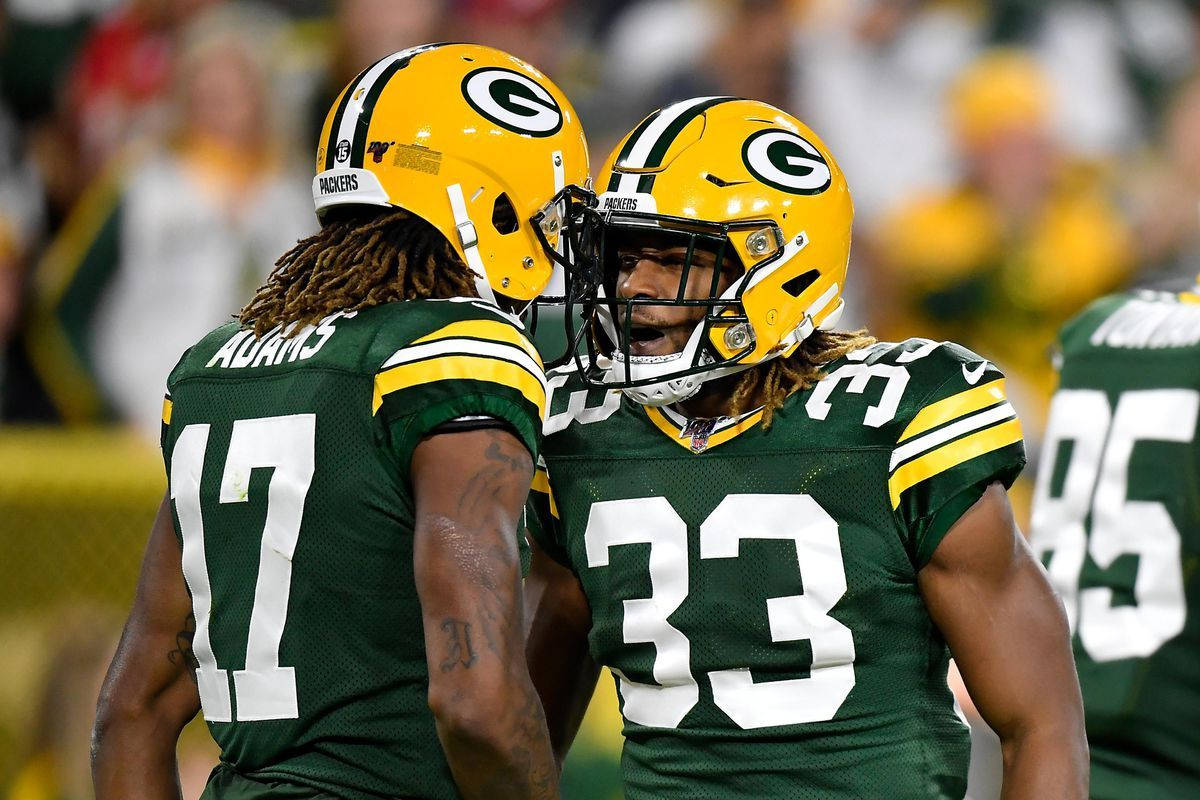 Davante Adams 桌布 壁紙 — 兩名綠灣包裝工美式足球員身穿綠色和金色球衣，在比賽期間於球場上緊密慶祝。