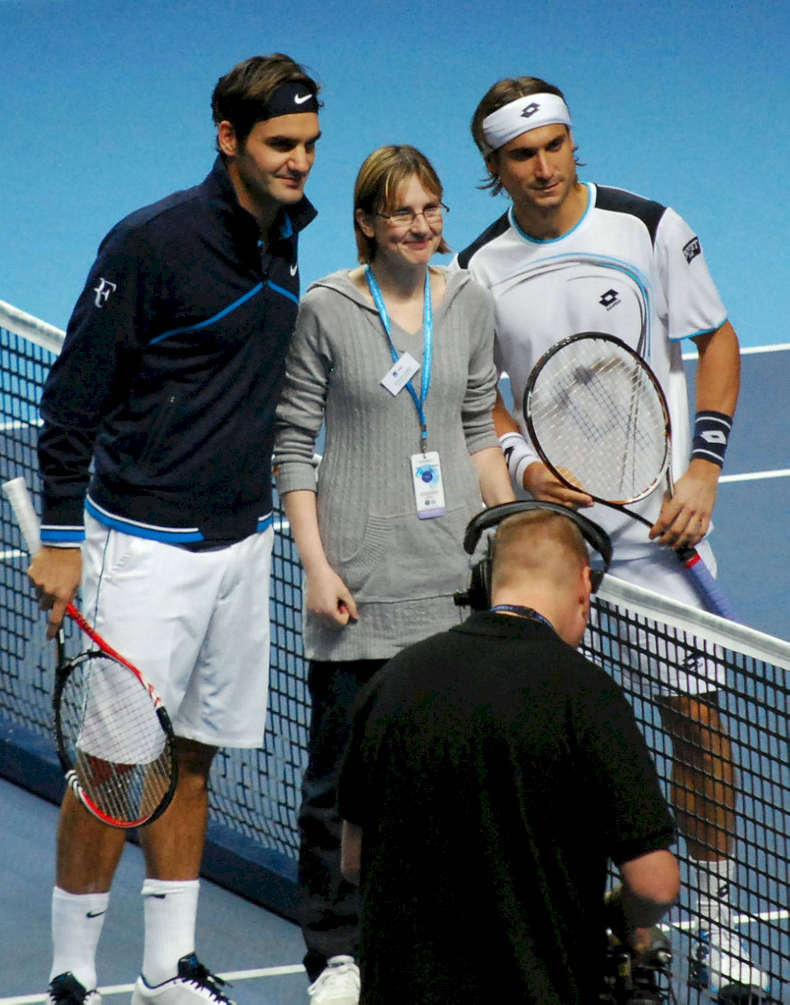 Tennis 桌布 壁紙 — 兩名網球選手和一名女子站在藍色球場上，攝影師正在拍攝他們。