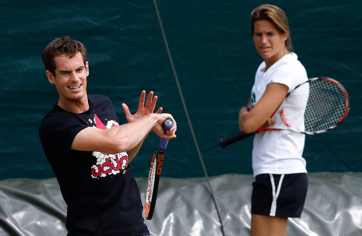 Tennis 桌布 壁紙 — 兩名網球選手在紅土球場上比賽，一人揮拍時咧嘴笑，另一人專注觀看。