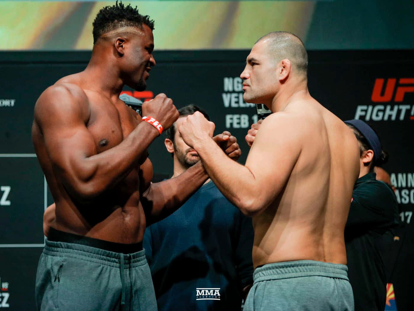 UFC 桌布 壁紙 — 兩名肌肉發達的MMA拳手在明亮的場館燈光下進行緊張的賽前對視。