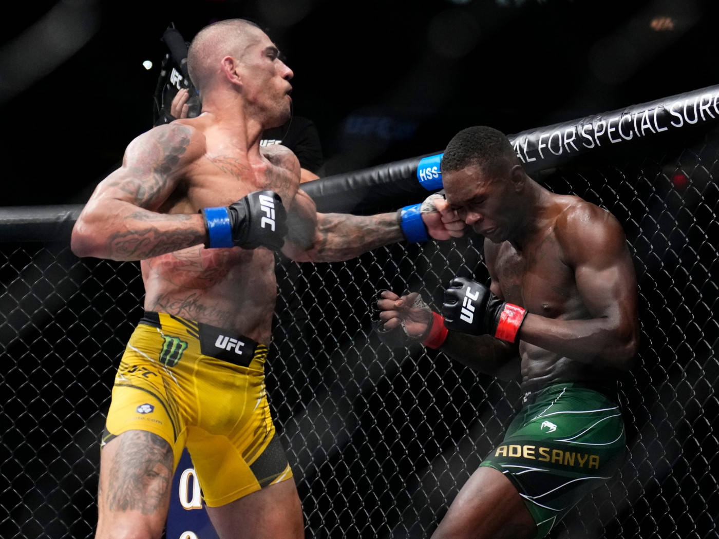 UFC 桌布 壁紙 — 兩名肌肉發達的MMA拳手在激烈的鐵籠賽中交鋒，其中一人向對手面部打出強力一拳。