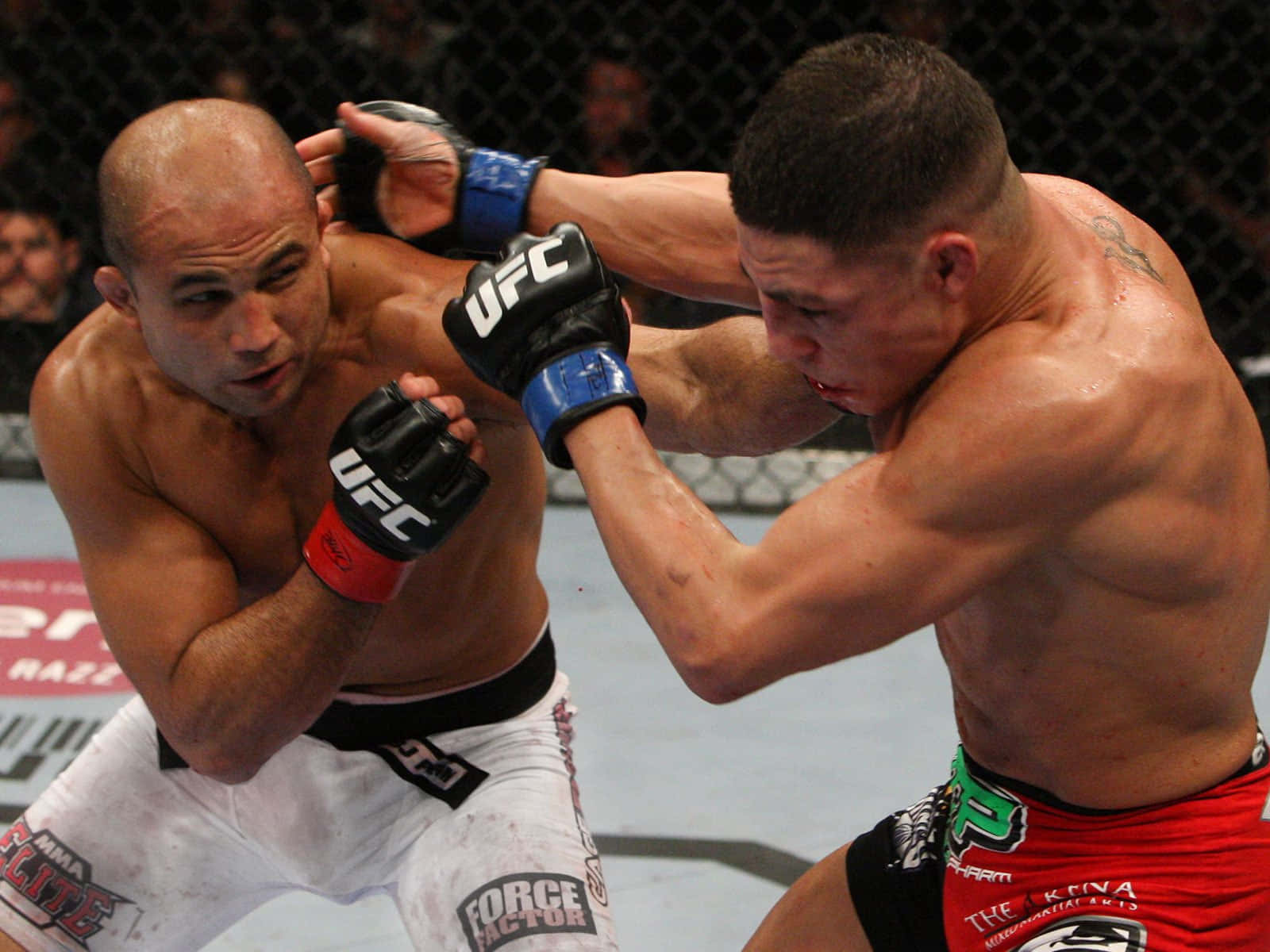 UFC 桌布 壁紙 — 兩名肌肉發達的MMA拳手在激烈的鐵籠賽中對戰，汗水飛濺，手套交纏。