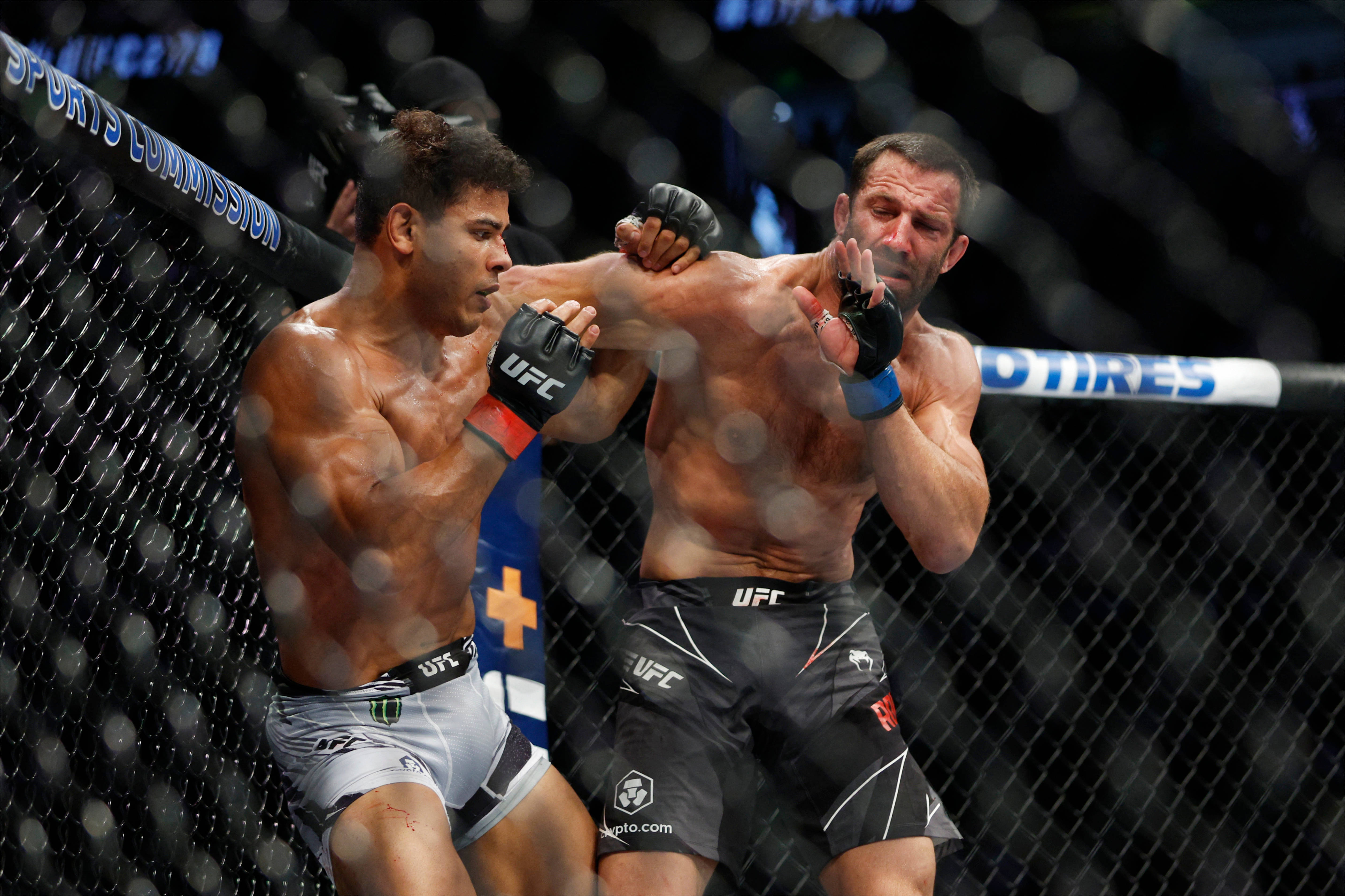 UFC 桌布 壁紙 — 兩名肌肉發達的MMA拳手在籠中激烈交鋒，汗水飛濺，其中一人使出強力肘擊。