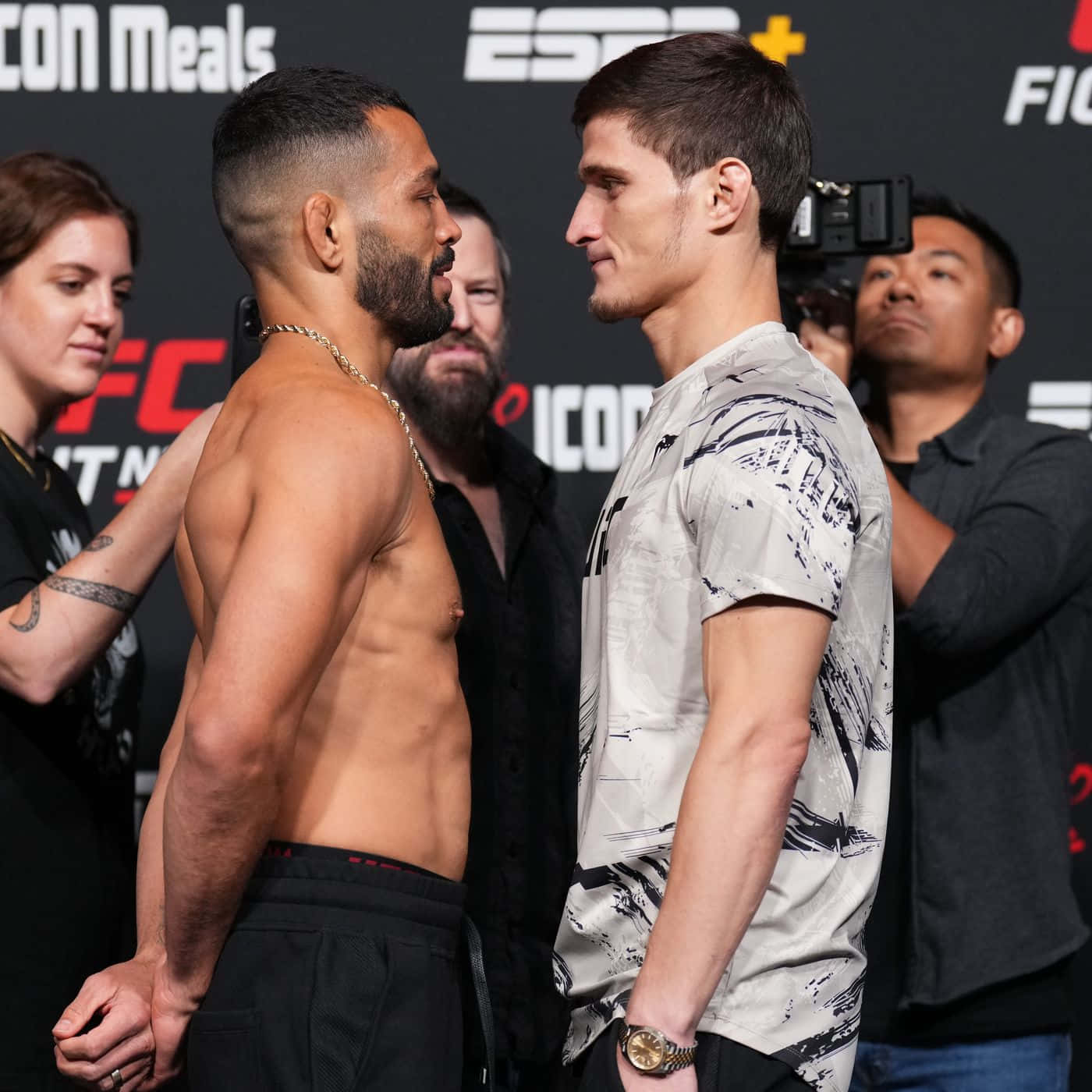 martial arts 桌布 壁紙 — 兩名肌肉發達的UFC拳手在ESPN品牌背景的稱重活動中，進行緊張的賽前對視。