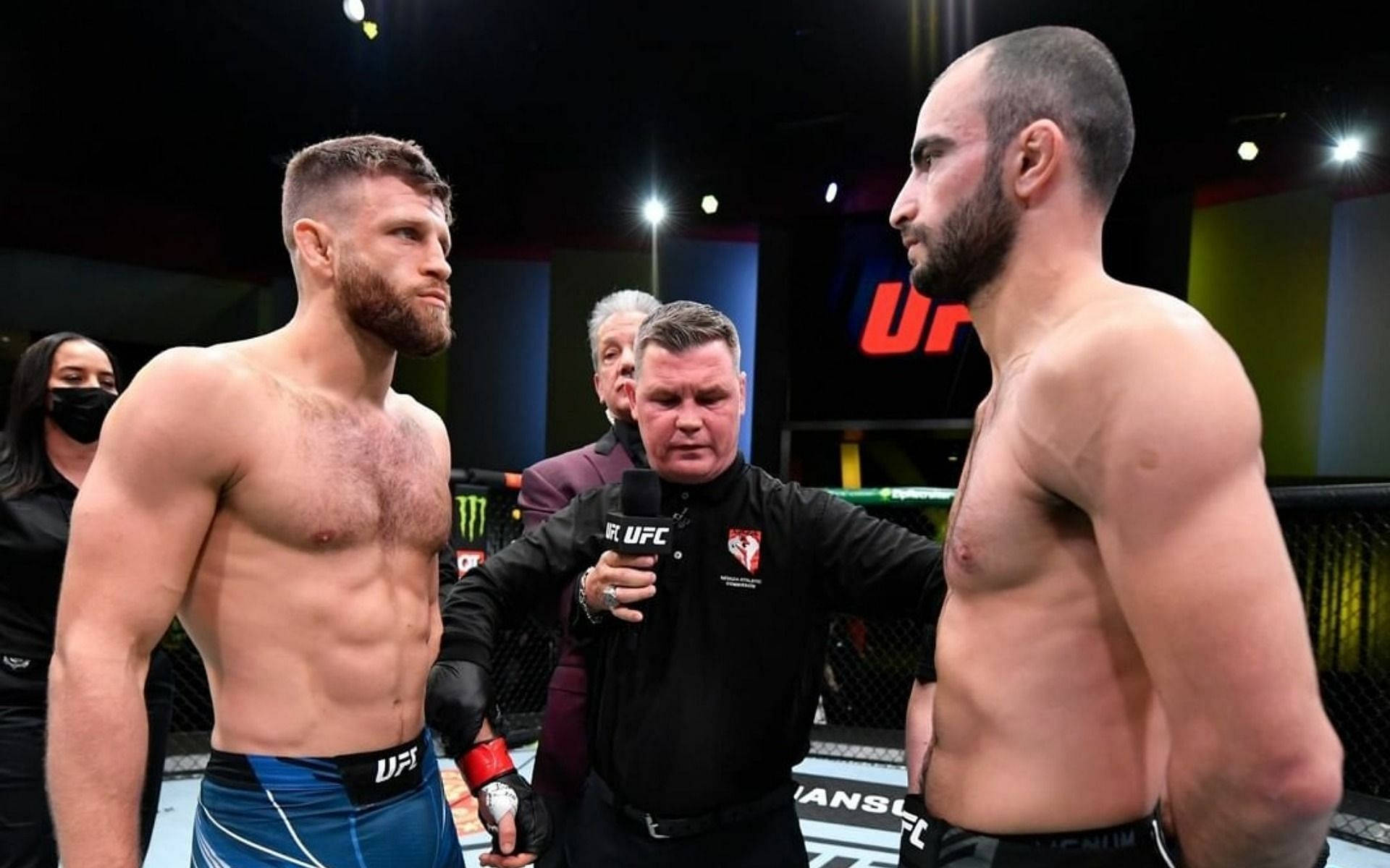 UFC 桌布 壁紙 — 兩名肌肉發達的UFC拳手在明亮的場館燈光下於八角籠中對峙，中間有裁判。