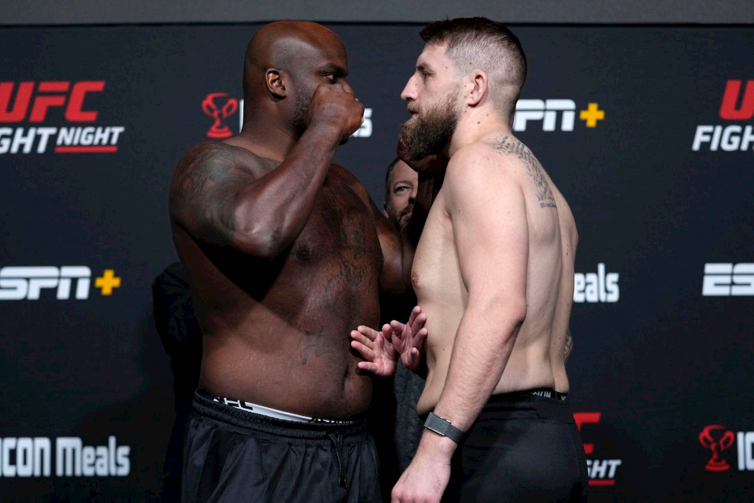MMA 桌布 壁紙 — 兩名肌肉發達的UFC拳手在有品牌背景的稱重活動中激烈對峙。