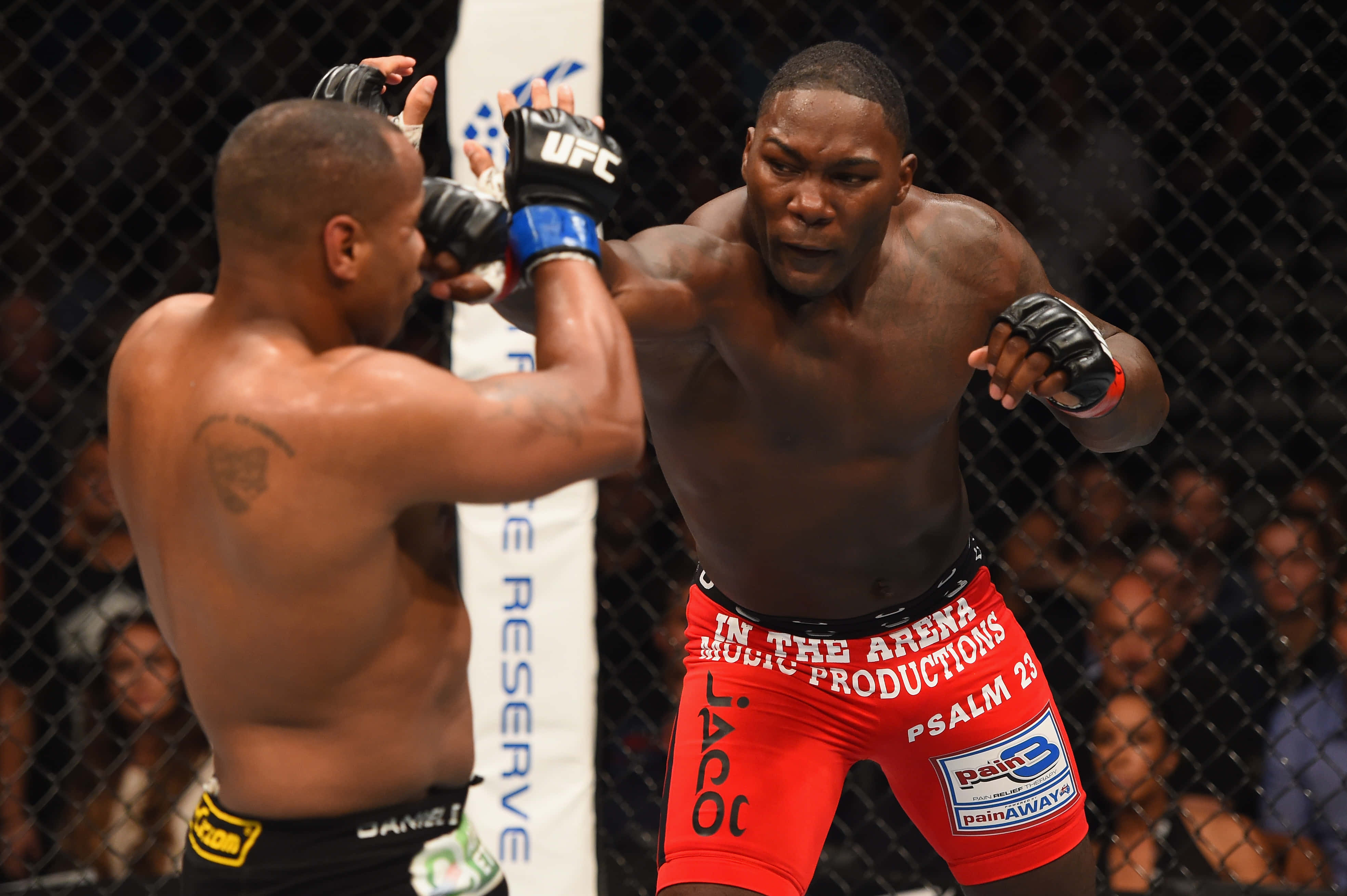 MMA 桌布 壁紙 — 兩名肌肉發達的拳手在UFC八角籠中交鋒，一人打出強力一拳，另一人則阻擋。