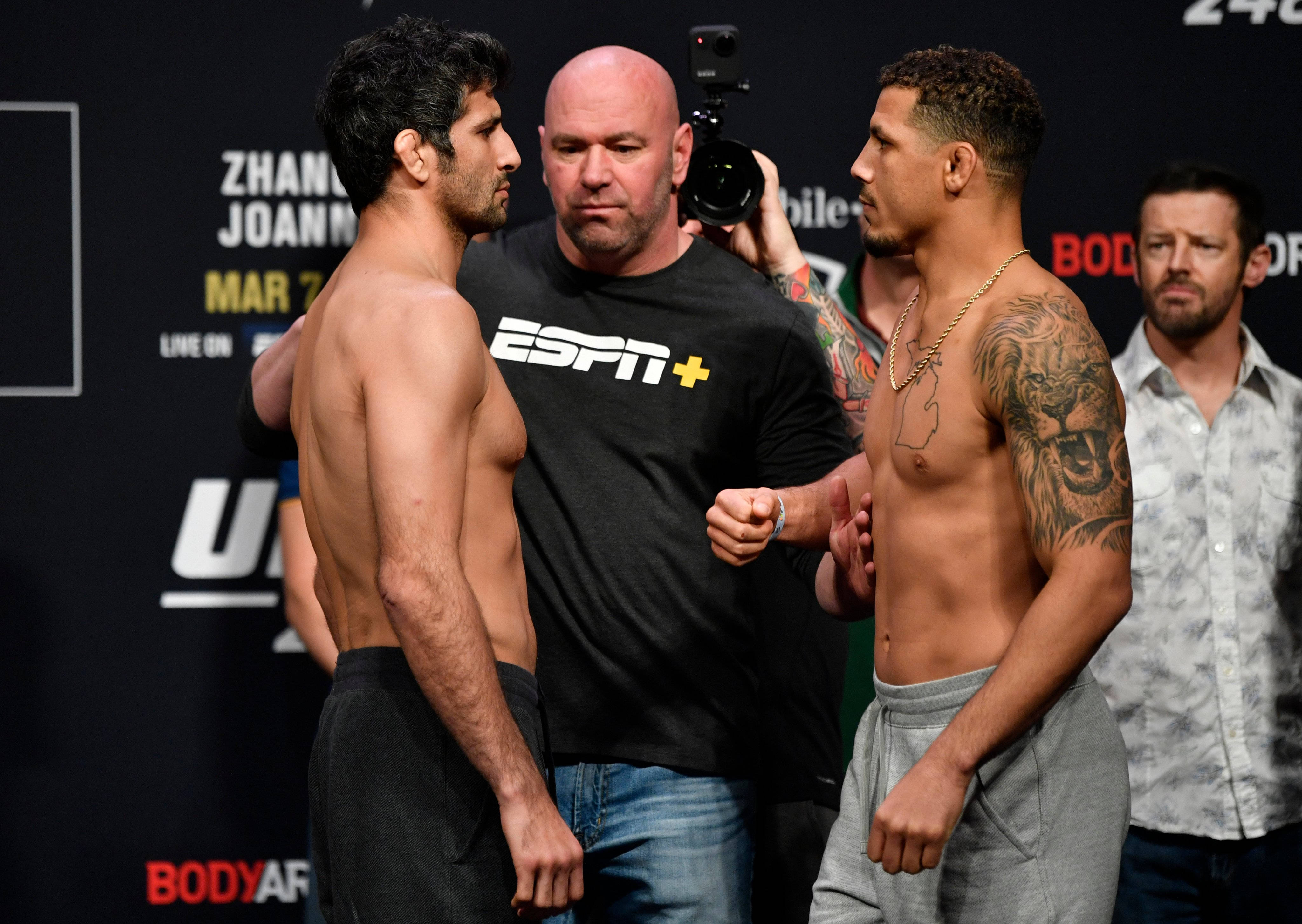 UFC 桌布 壁紙 — 兩名肌肉發達的拳手在UFC稱重儀式上對峙，背景有裁判和攝影團隊。