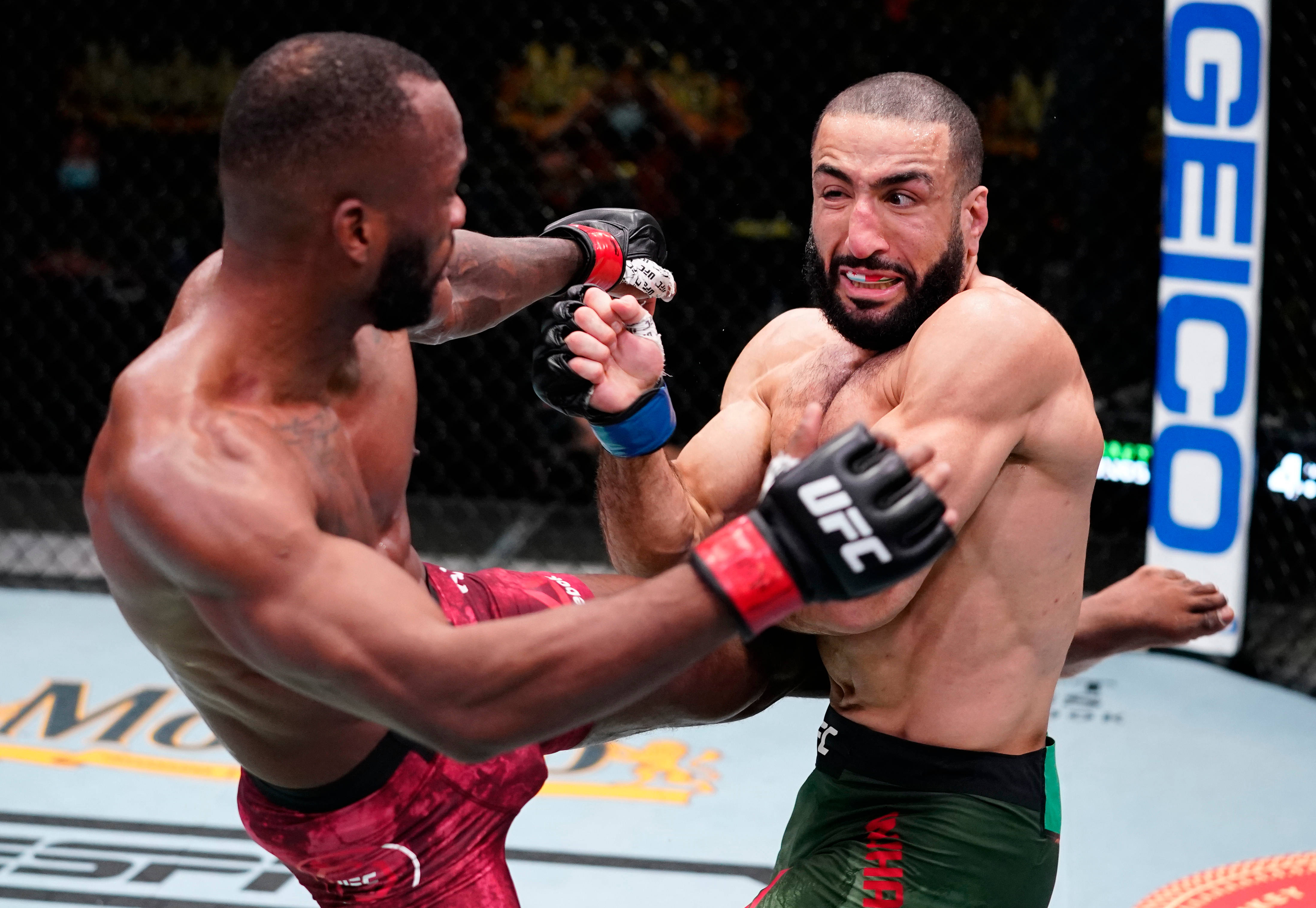 MMA 桌布 壁紙 — 兩名肌肉發達的拳手在八角籠內進行高強度MMA比賽，贊助商標誌清晰可見。