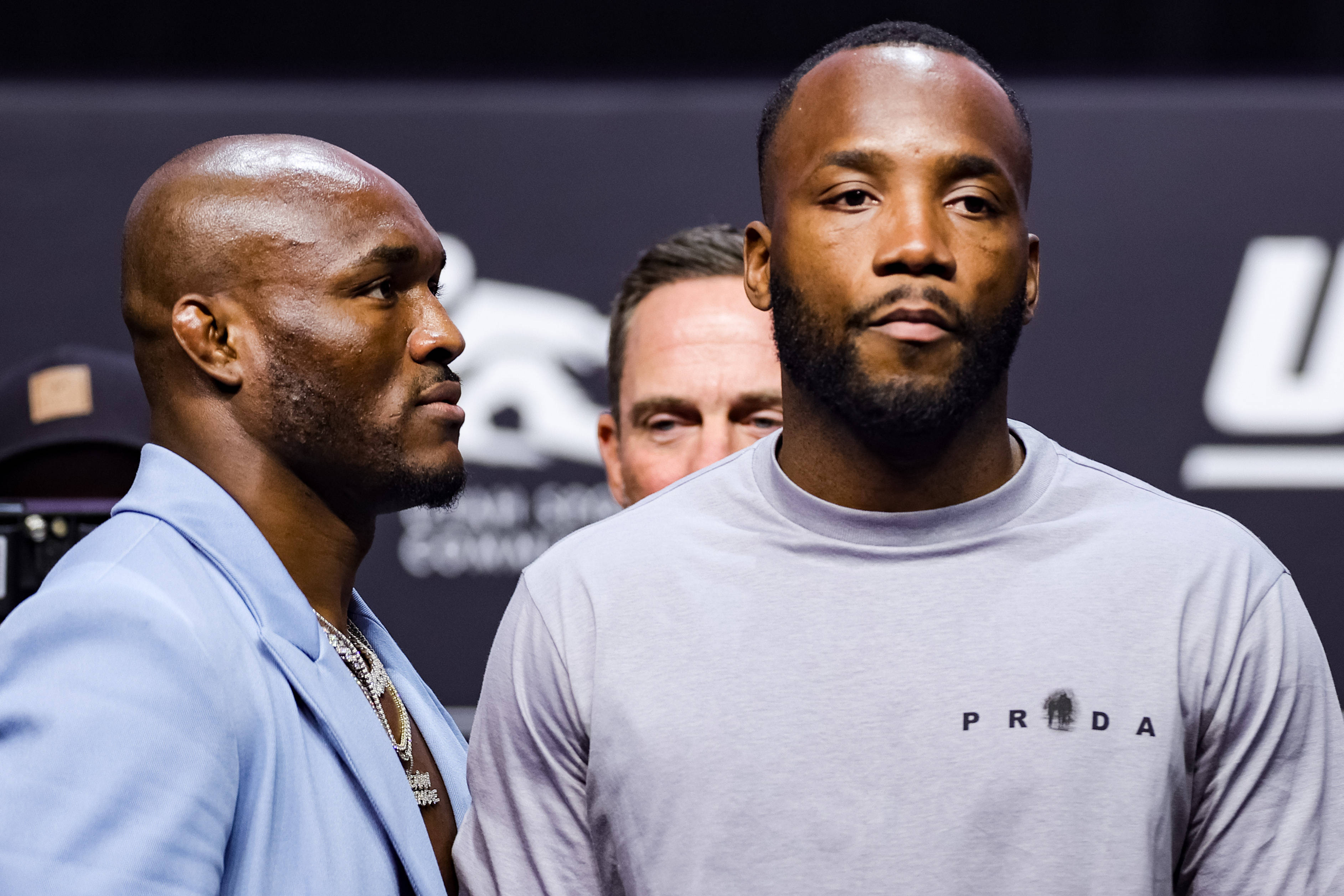 MMA 桌布 壁紙 — 兩名肌肉發達的拳手在明亮的攝影棚燈光下，於 UFC 稱重活動中對峙，表情激烈。
