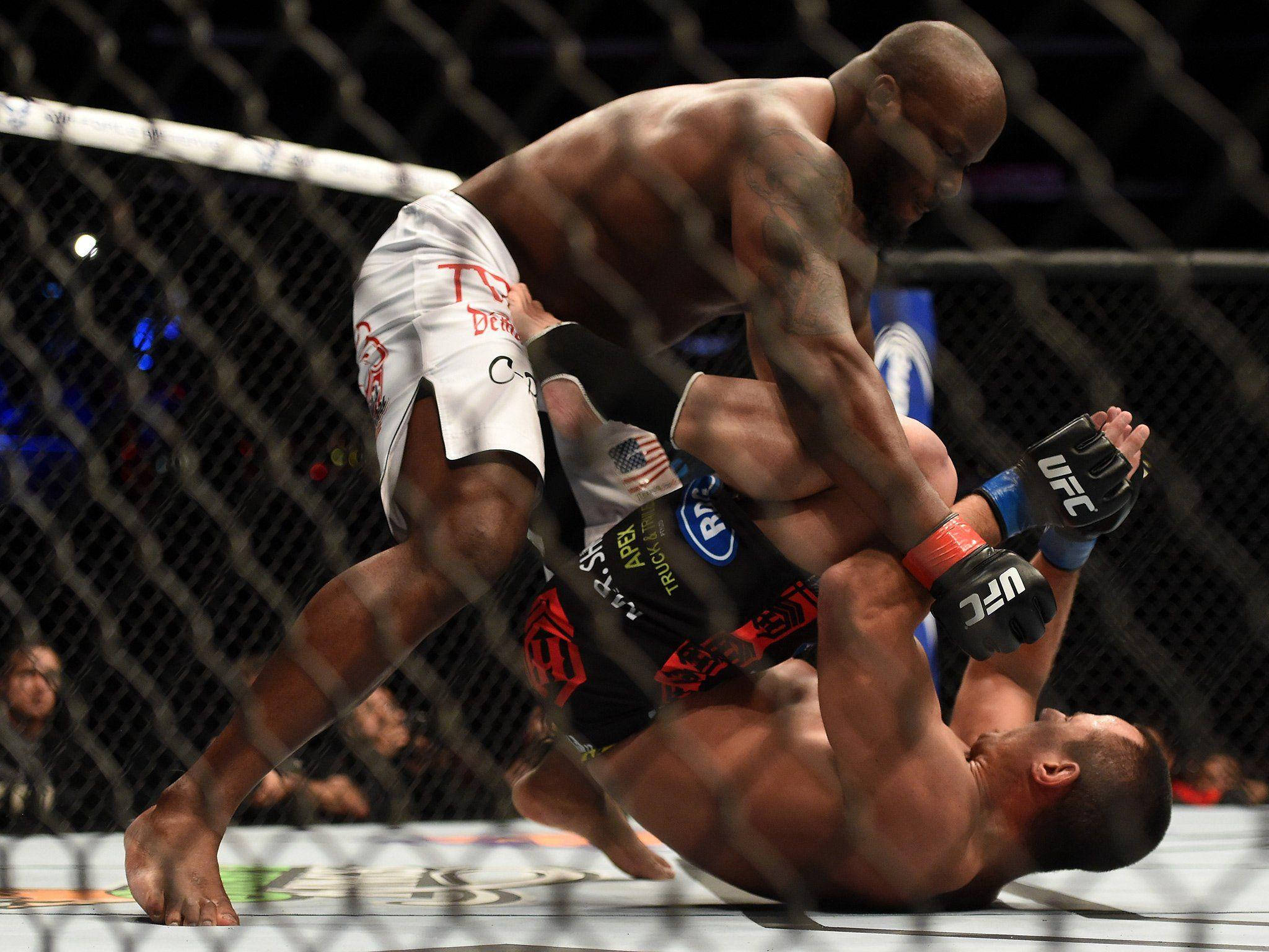 MMA 桌布 壁紙 — 兩名肌肉發達的拳手在明亮的競技場燈光下，於籠式八角籠內激烈纏鬥。