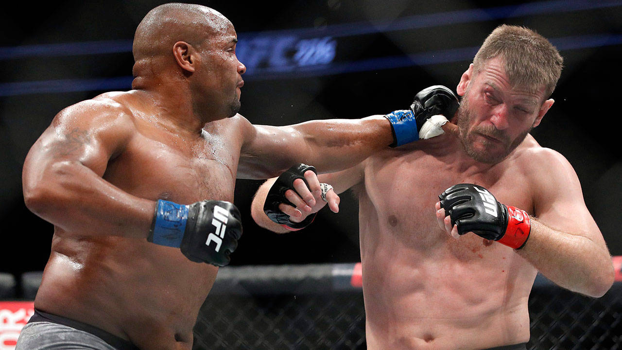 UFC 桌布 壁紙 — 兩名肌肉發達的拳手在激烈的UFC比賽中碰撞，汗水飛濺，其中一人打出強力一拳。