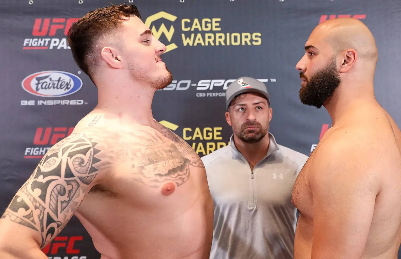 UFC 桌布 壁紙 — 兩名肌肉發達的拳手在稱重時互相怒視，裁判在他們之間觀看。