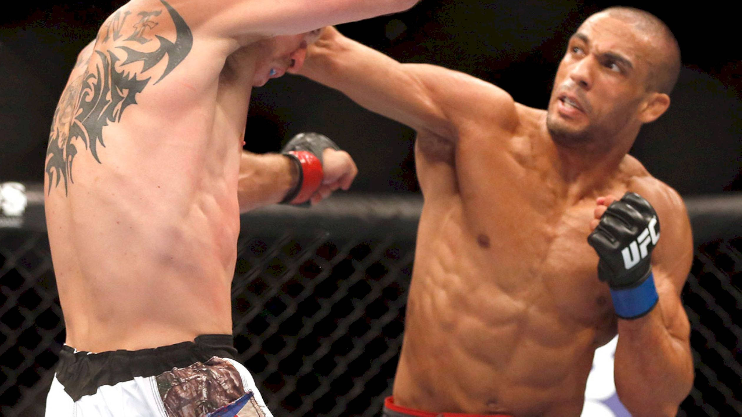 MMA 桌布 壁紙 — 兩名肌肉發達的拳手在籠中交鋒，其中一人向對手頭部猛烈出拳。