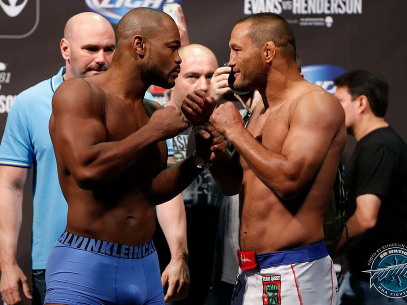 UFC 桌布 壁紙 — 兩名肌肉發達的拳手在緊張的賽前稱重中對峙，拳頭緊鎖，表情激烈。