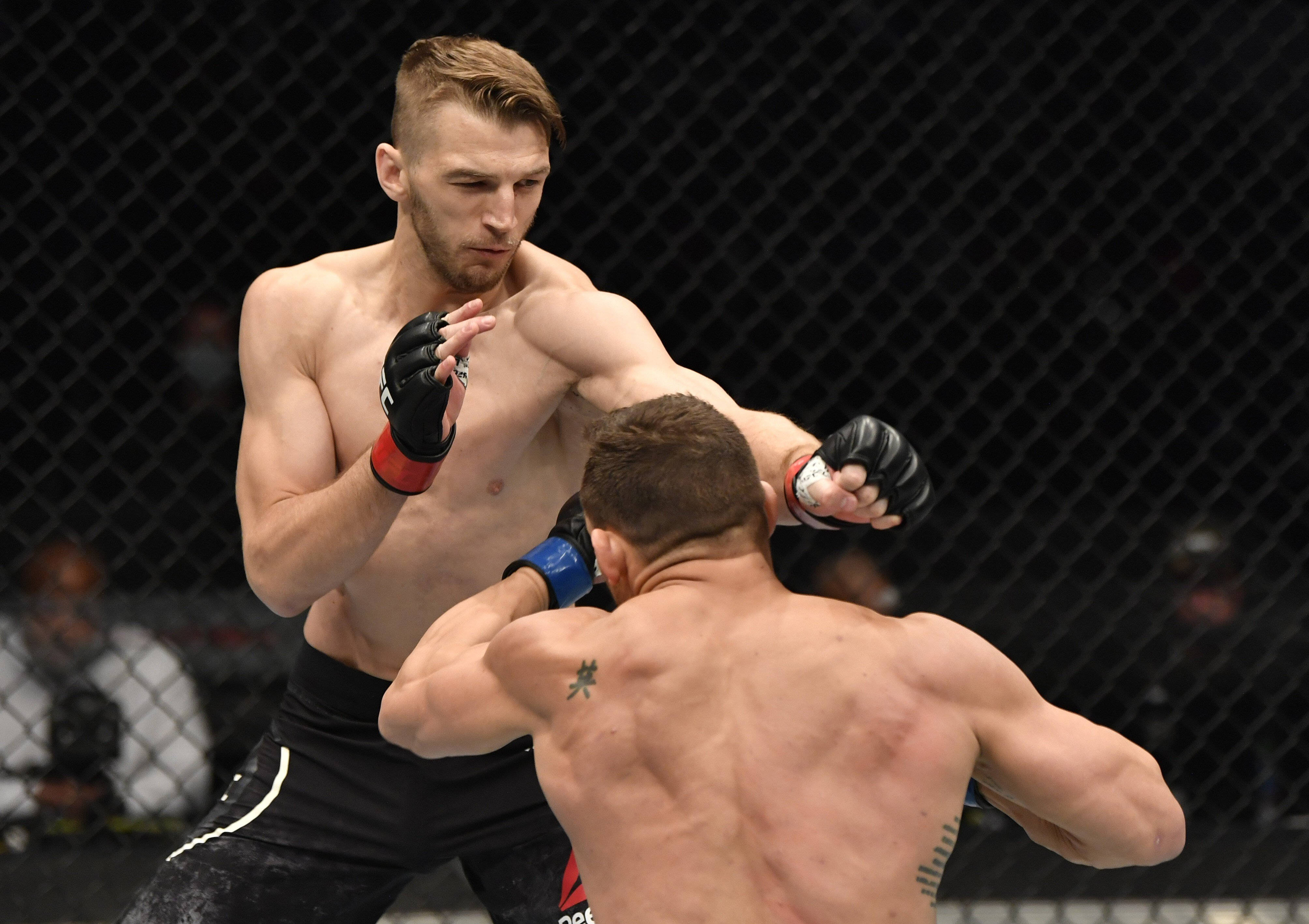 UFC 桌布 壁紙 — 兩名肌肉發達的拳手在鐵籠中交鋒，其中一人向對手的背部猛烈出拳。