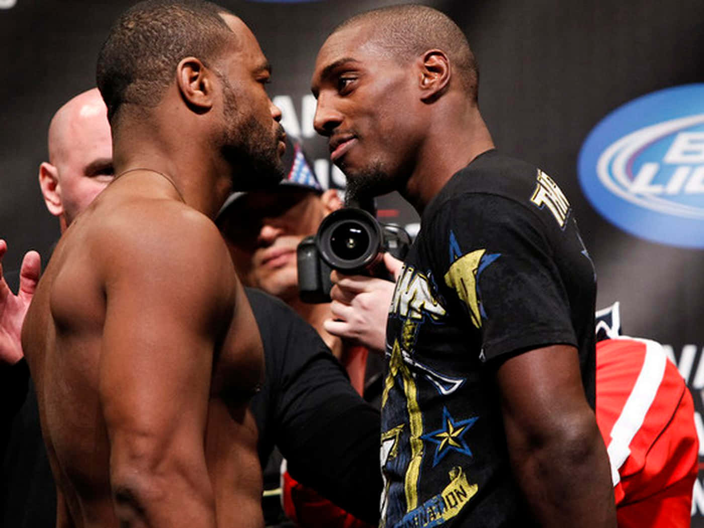 UFC 桌布 壁紙 — 兩名肌肉發達的拳手在閃光燈環繞的稱重儀式上激烈對峙。