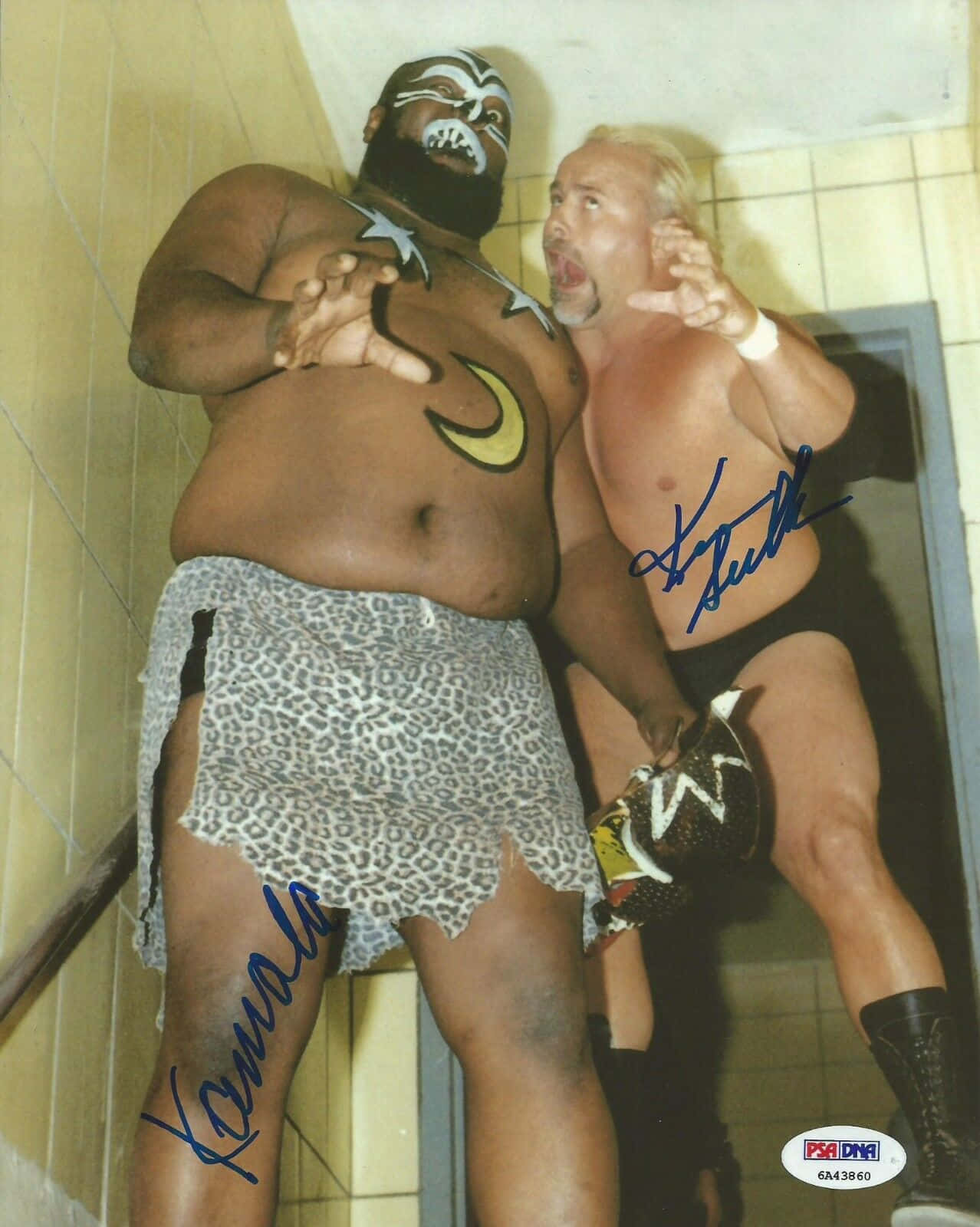WWE 桌布 壁紙 — 兩名肌肉發達的摔角手在瓷磚走廊上，一人穿著豹紋裙和臉部彩繪，另一人金髮穿靴，兩人都擺出戲劇性的姿勢。