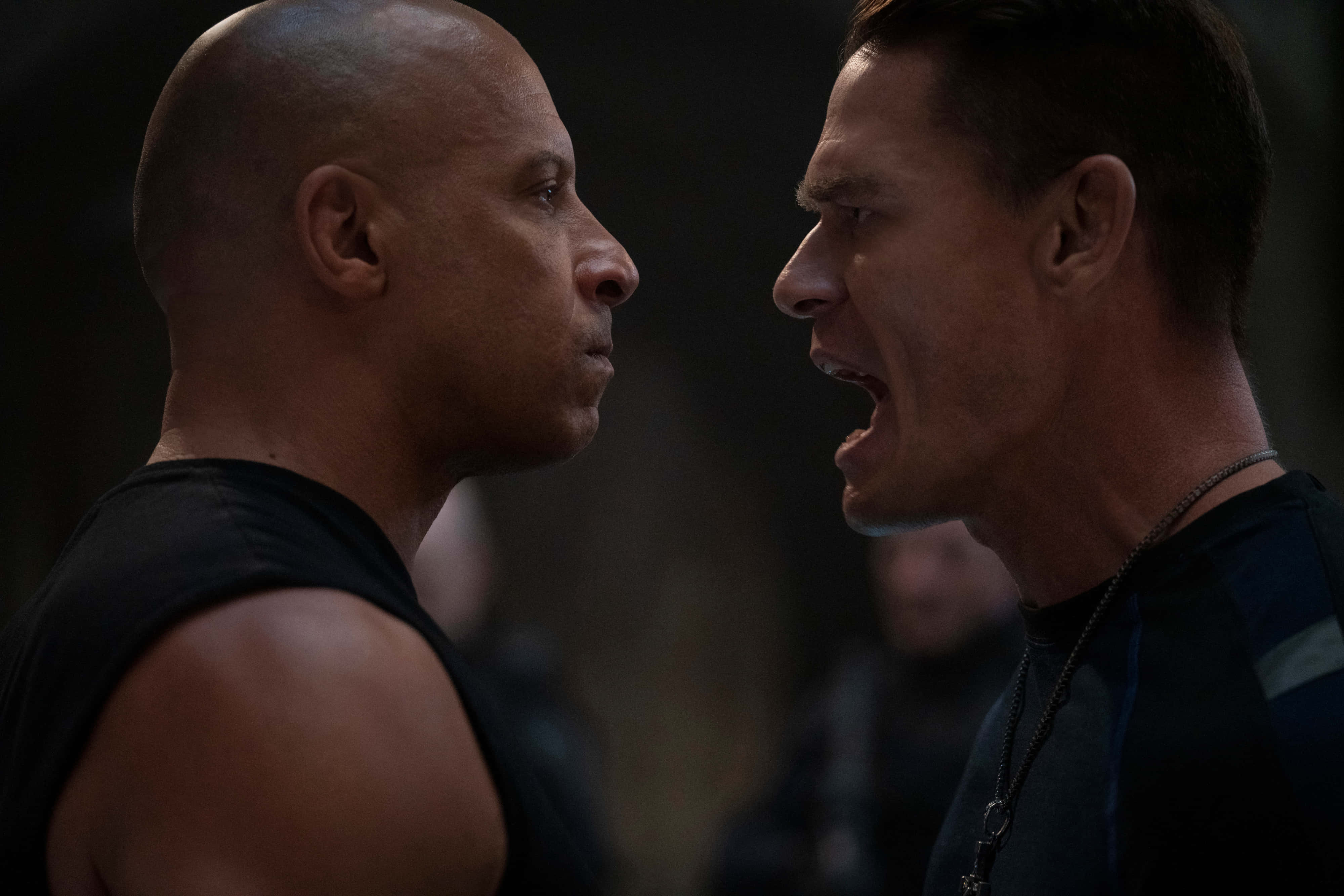 Fast Furious 9 桌布 壁紙 — 兩名肌肉發達的男子在緊張的對峙中，表情強烈，燈光戲劇化。