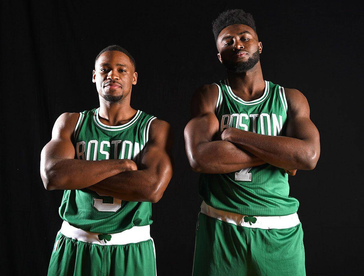 Jaylen Brown 桌布 壁紙 — 兩名肌肉發達的籃球運動員身穿綠色波士頓球衣，在黑色背景前自信地交叉雙臂站立。