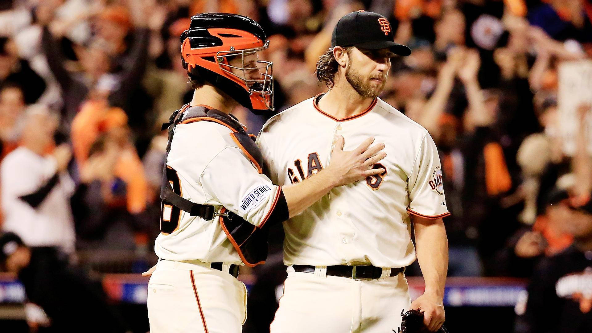 madison bumgarner 桌布 壁紙 — 兩名舊金山巨人隊棒球選手在夜間比賽中擁抱慶祝，背景是歡呼的球迷。