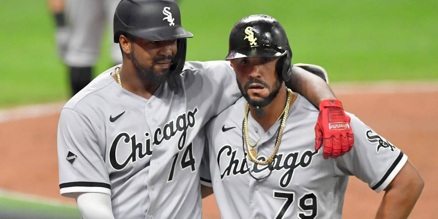 jose abreu 桌布 壁紙 — 兩名芝加哥白襪棒球運動員身穿灰色制服在球場上擁抱，球場燈光下。