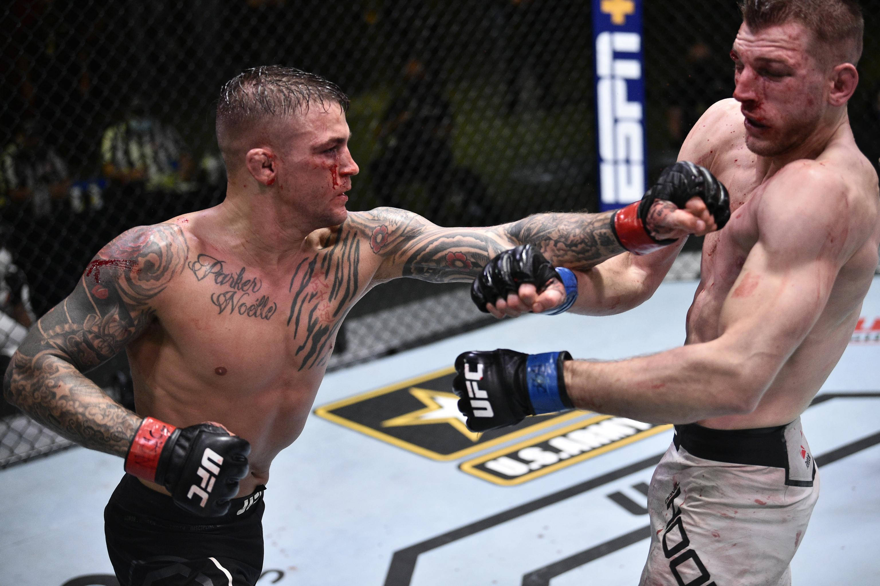 UFC 桌布 壁紙 — 兩名血跡斑斑的MMA拳手在明亮的場館燈光下進行激烈的籠中對決。