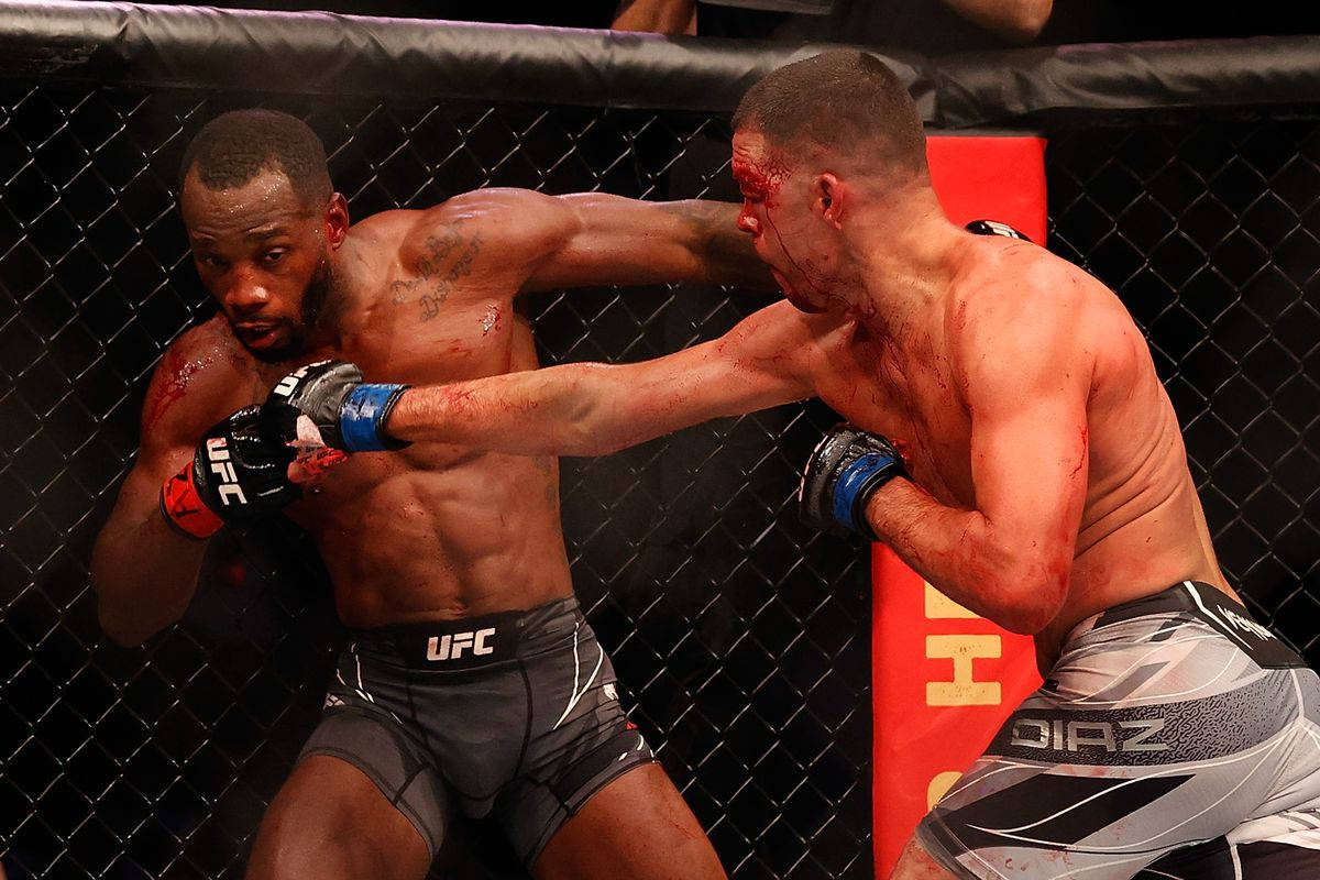 MMA 桌布 壁紙 — 兩名血跡斑斑的MMA拳手在明亮的場館燈光下進行激烈的籠中對決。
