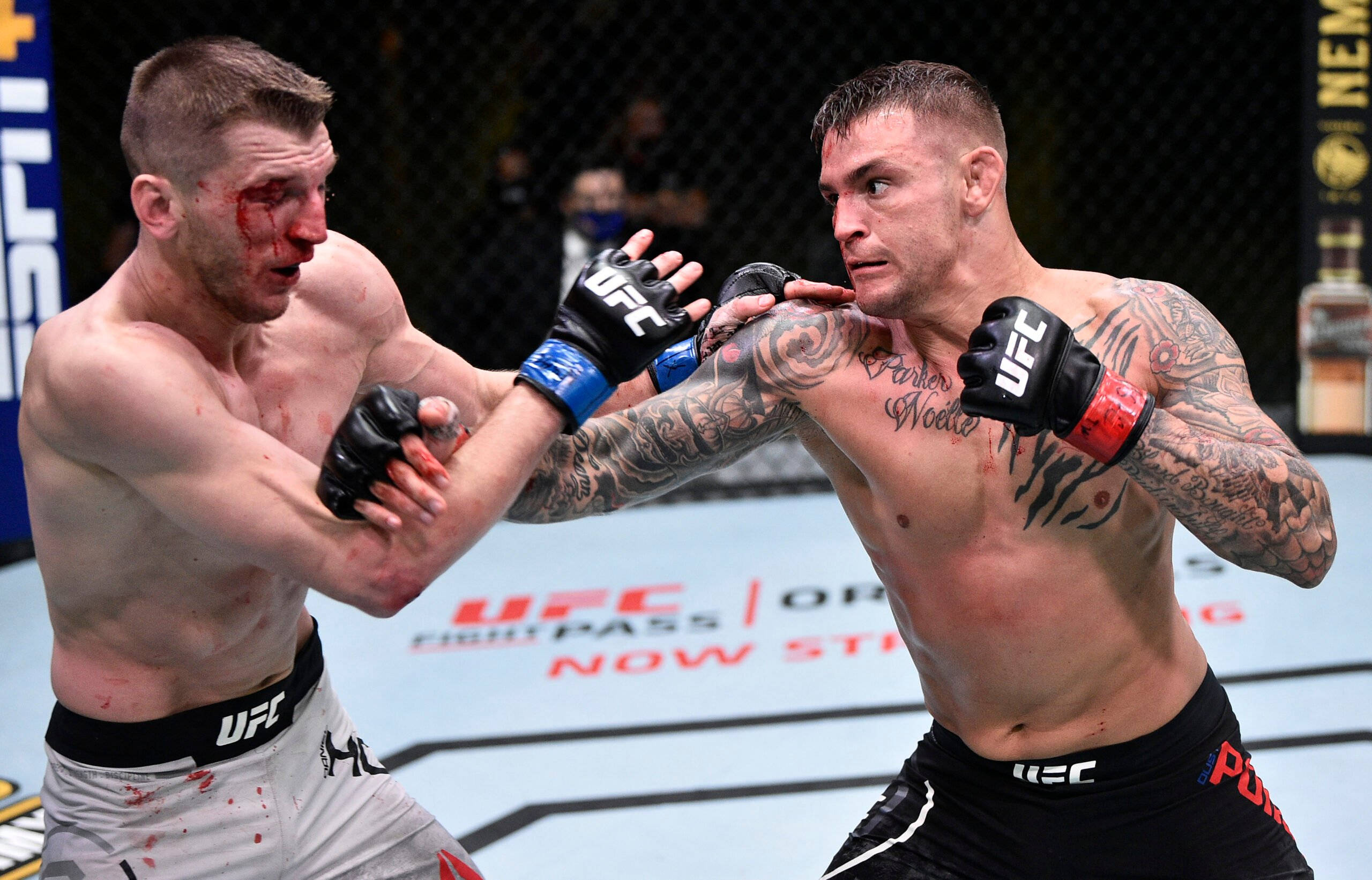 UFC 桌布 壁紙 — 兩名血跡斑斑的MMA拳手在激烈的UFC八角籠比賽中碰撞，紋身和手套飛舞。
