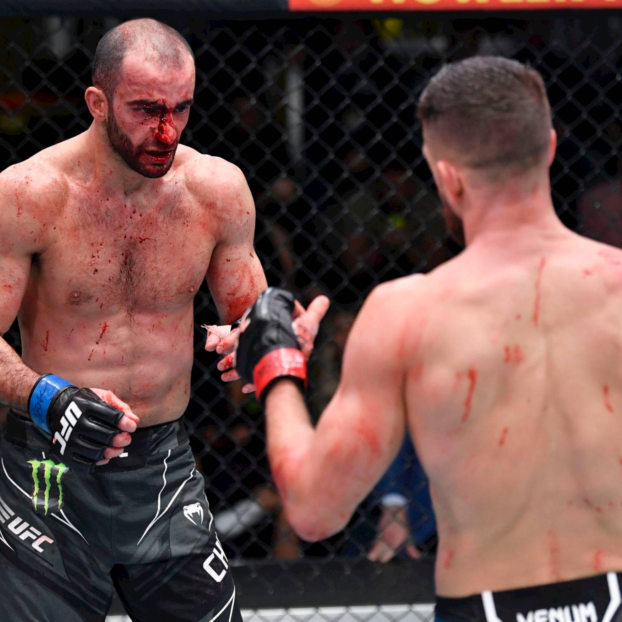 UFC 桌布 壁紙 — 兩名血跡斑斑的MMA拳手在鐵籠中於一場激烈比賽後握手。