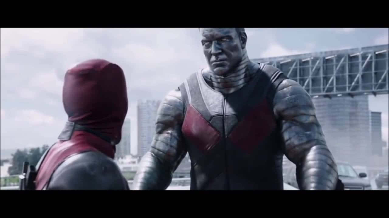 Deadpool And Colossus 桌布 壁紙 — 兩名裝甲超級英雄在多雲的天空下於 gritty 的城市環境中對峙。