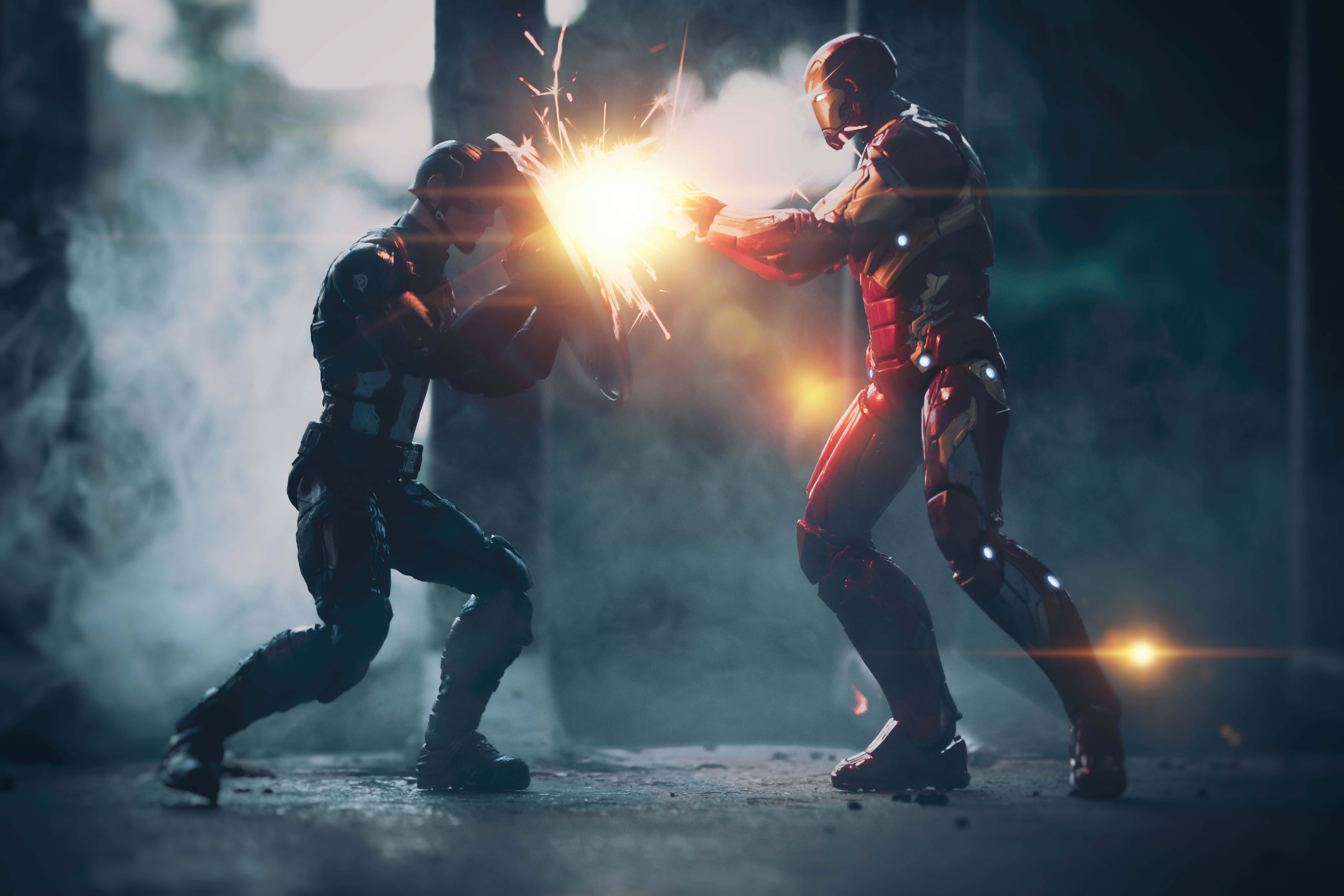 Iron Man Vs Captain America 桌布 壁紙 — 兩名裝甲超級英雄在煙霧瀰漫、燈光昏暗的環境中交鋒，武器碰撞迸發出明亮的火花。