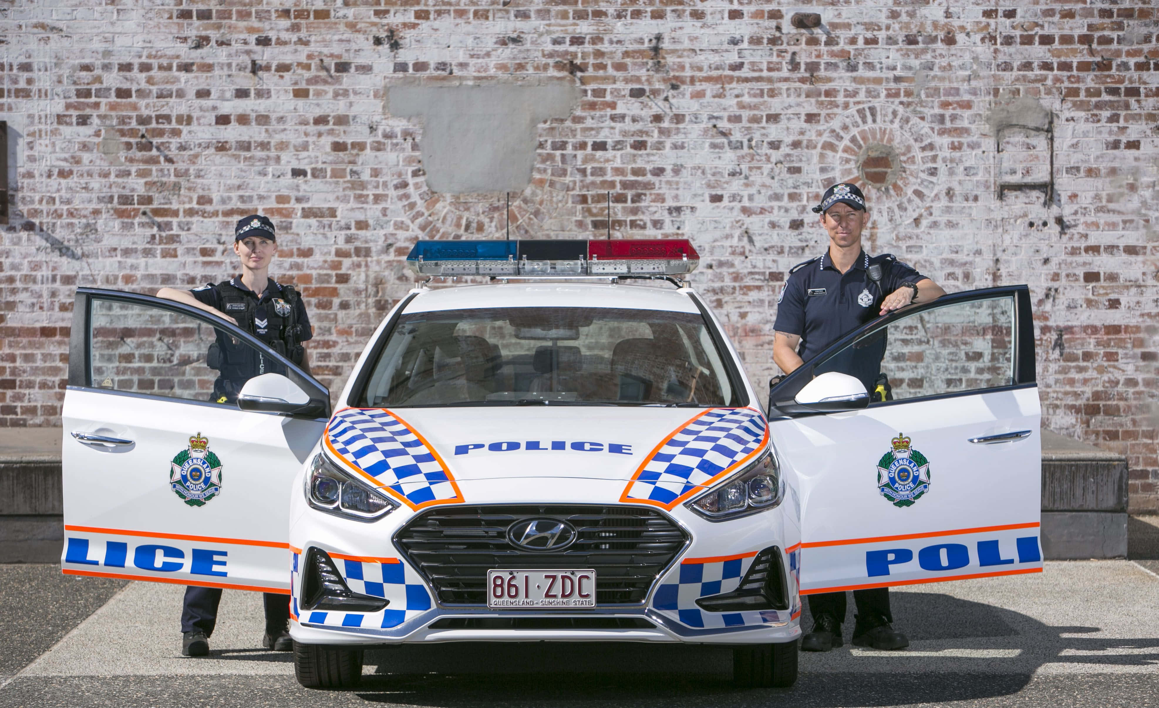 兩名警察站在警車旁 壁紙