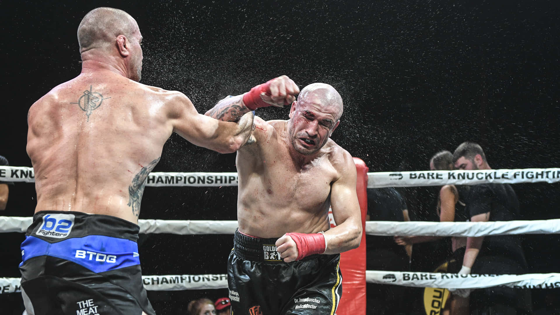 Boxing 桌布 壁紙 — 兩名赤手空拳的拳手在明亮的場館燈光下，於濺滿雨水的拳擊擂台上交鋒。