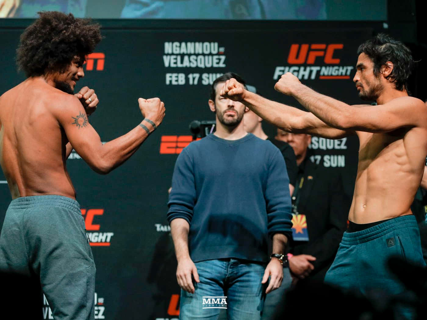 MMA 桌布 壁紙 — 兩名赤裸上身的MMA拳手在UFC賽事中，在裁判之間進行緊張的賽前對視。