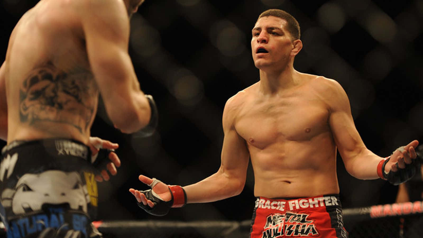 UFC 桌布 壁紙 — 兩名赤裸上身的MMA拳手在八角籠中對峙，一人展示刺青背部，另一人穿著紅色短褲。