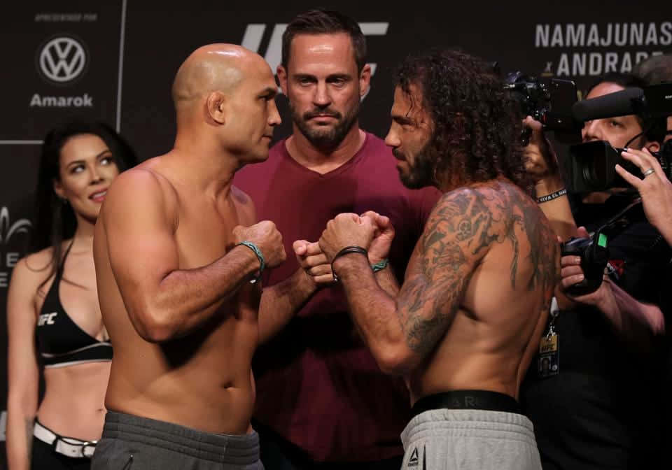 UFC 桌布 壁紙 — 兩名赤裸上身的MMA拳手在明亮的場館燈光下，於緊張的賽前對峙中鎖住拳頭。