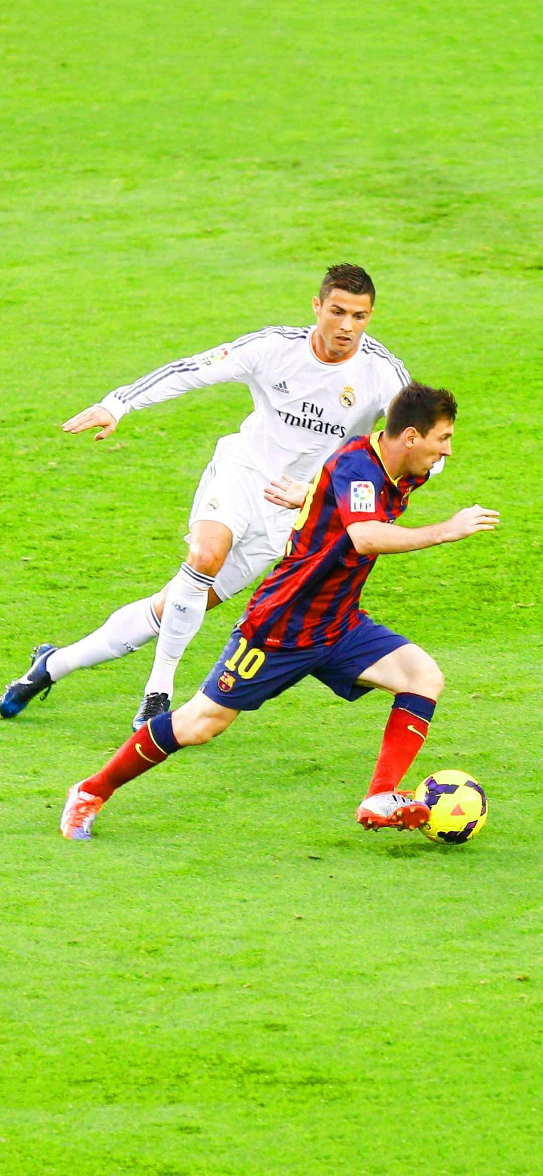 Messi And Ronaldo 4K 桌布 壁紙 — 兩名足球運動員在明亮的體育場燈光下，在充滿活力的綠色球場上激烈爭奪一個球。