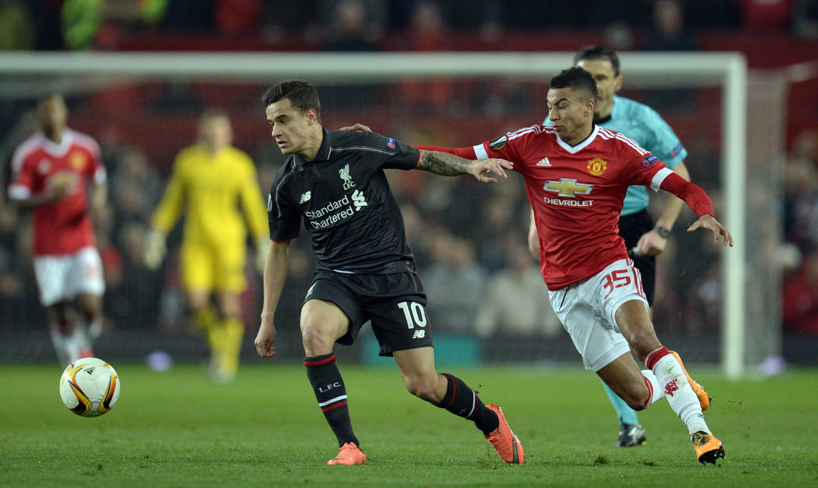 Coutinho 桌布 壁紙 — 兩名足球運動員在體育場燈光下，在充滿活力的綠色球場上激烈爭球。