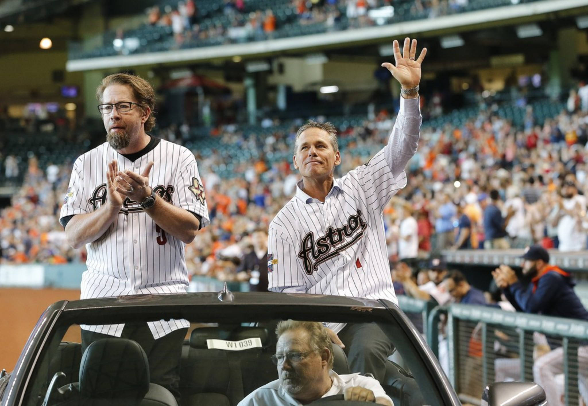 Craig Biggio 桌布 壁紙 — 兩名身穿Astros球衣的男子在體育館慶祝活動中，從敞篷車上揮手鼓掌，身後是歡呼的人群。