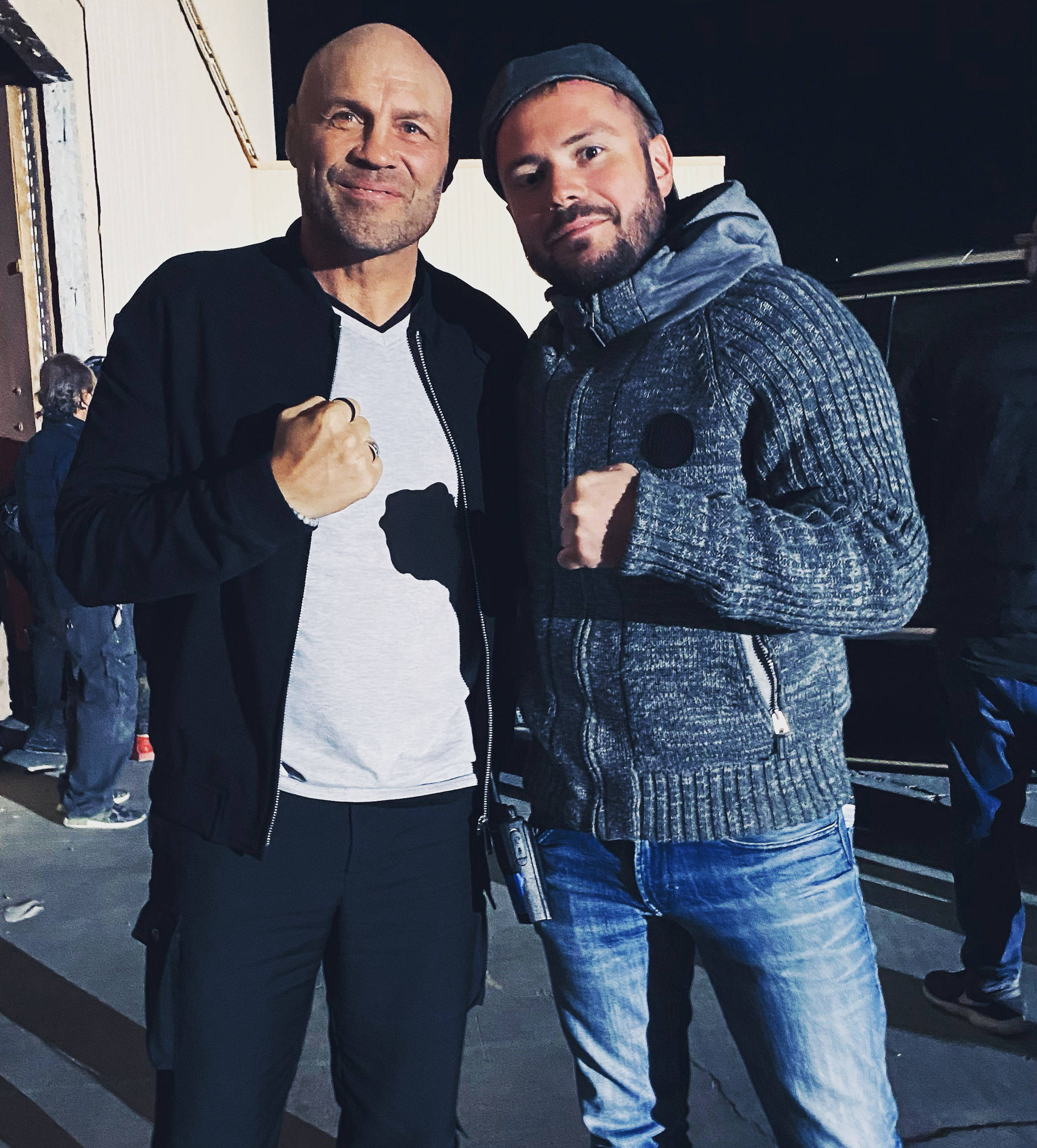 MMA 桌布 壁紙 — 兩名身穿休閒服的男子在夜間明亮的人造燈光下自信地舉起拳頭擺姿勢。