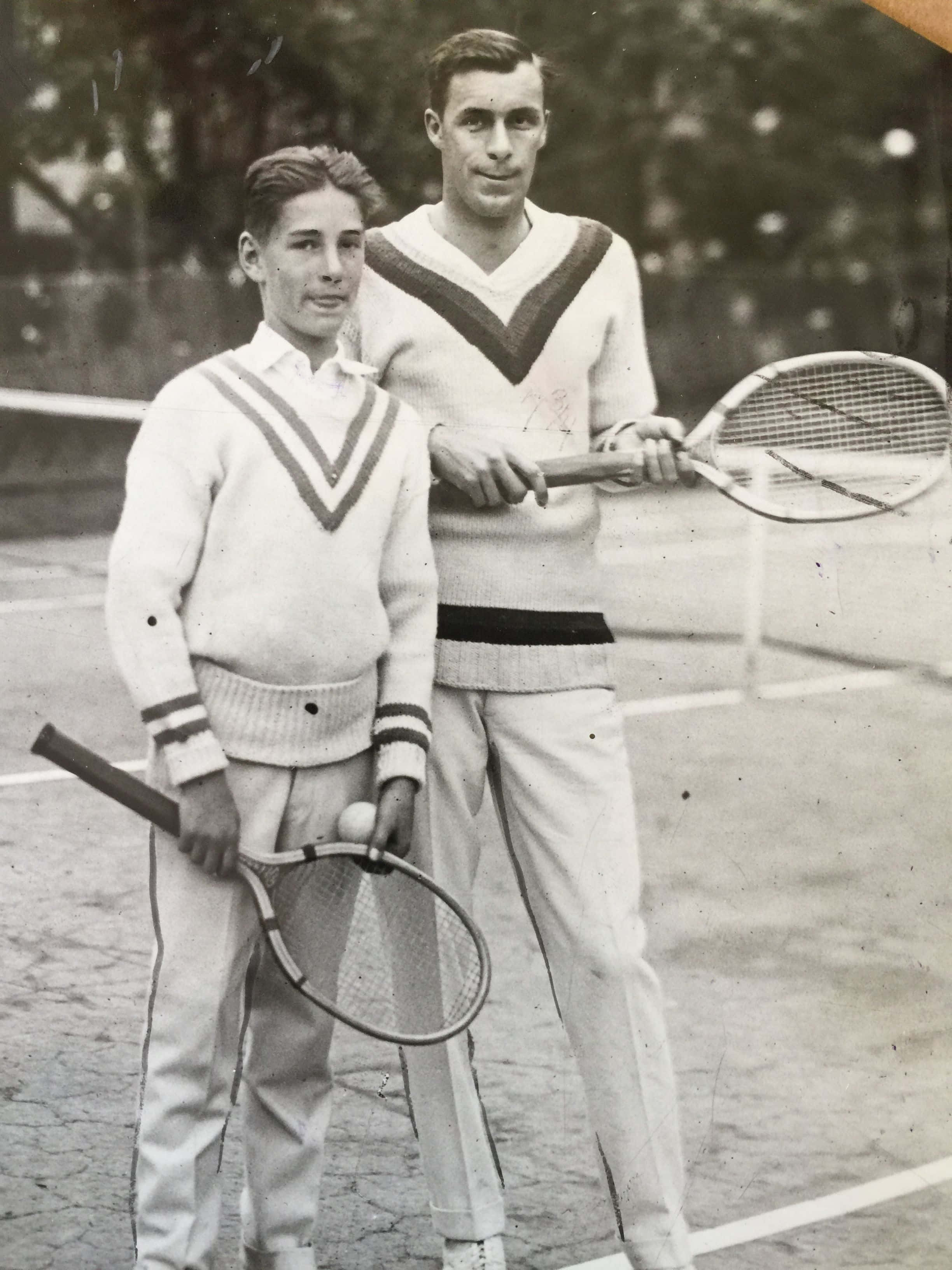Tennis Ball 桌布 壁紙 — 兩名身穿復古網球毛衣的男子在球場上擺姿勢，一人手持球拍和球，另一人以自信的姿態握緊球拍。