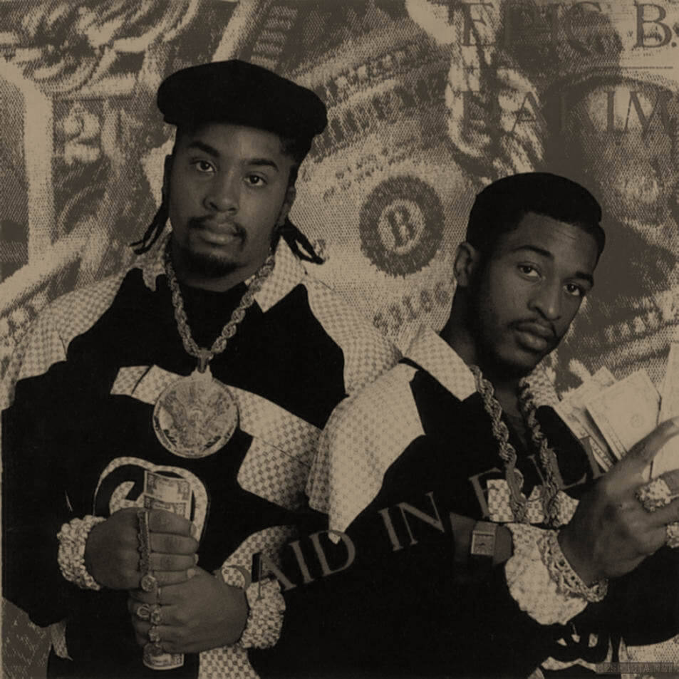 Album Cover 桌布 壁紙 — 兩名身穿格紋外套和戴金鏈的男子在金錢主題背景前自信地擺姿勢。